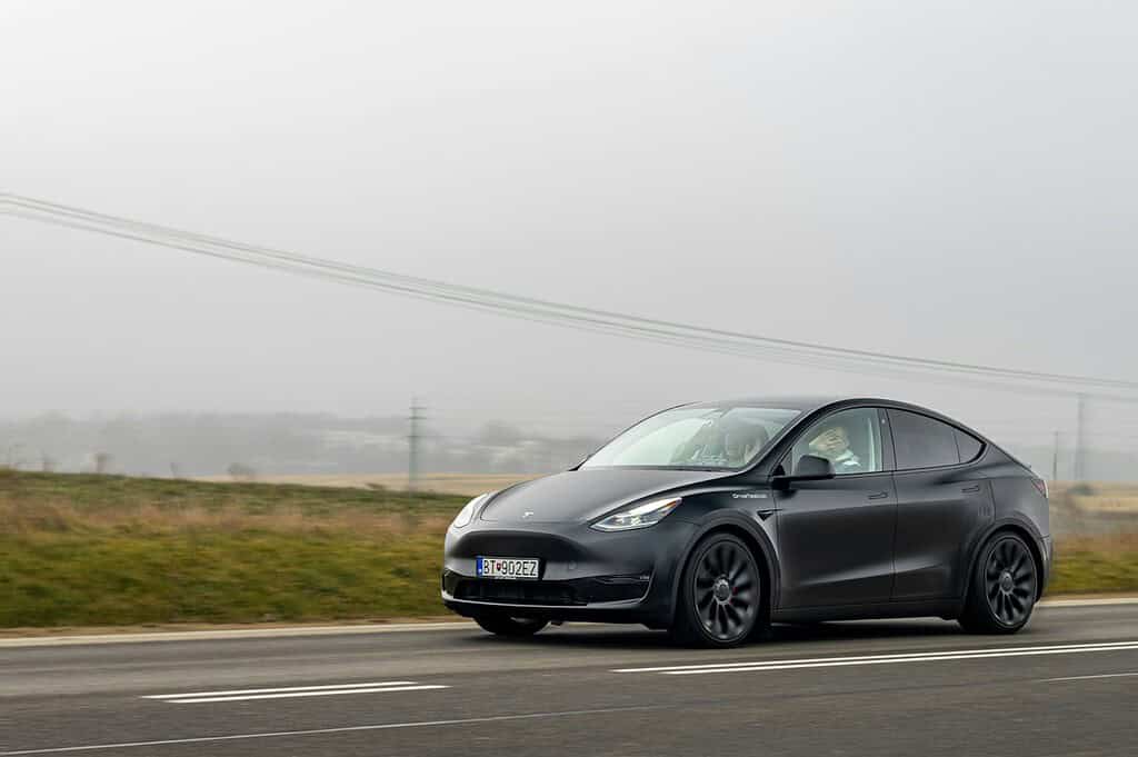 Tesla Model Y on scenic road, illustrative archive