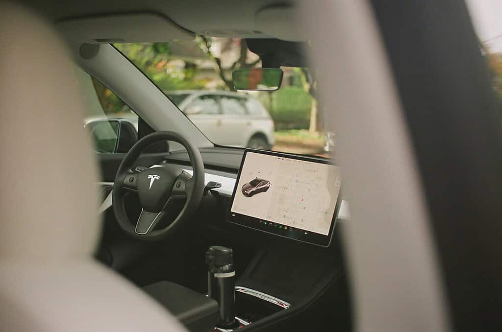 Dashboard touchscreen and cabin photo; illustrative, not a verified FSD update screen